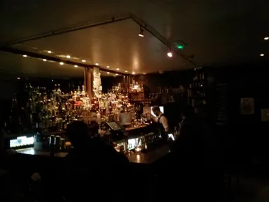 There are a lot of drinks behind the bar. Some of them are beer.