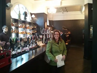 Emily stands in the London-style bar area. Look at the whisky!