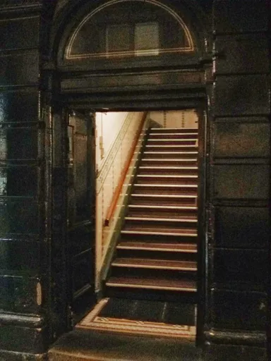 No sign. Just look for the stairs directly to the right of Storey's Amusements.