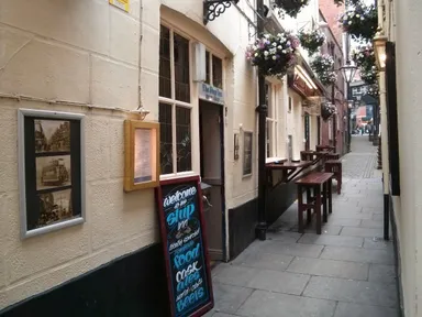 A few tables and chairs sit out in this narrow beer garden.