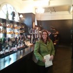 Emily stands in the London-style bar area. Look at the whisky!